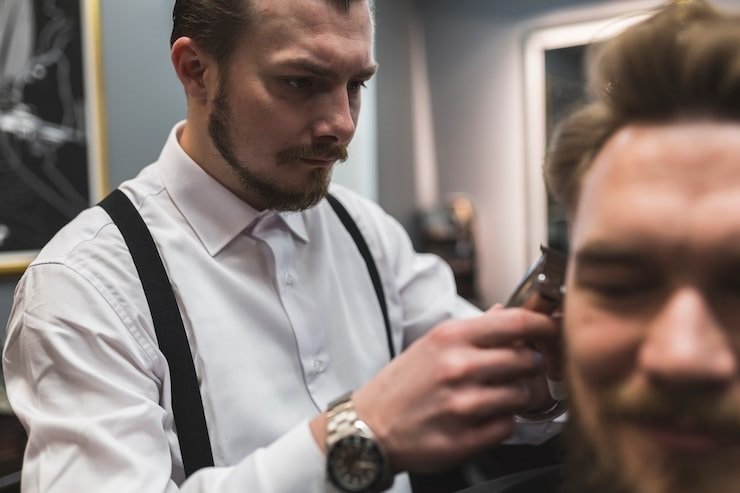 Barber shaving and detailing a clean professional hairstyle for men