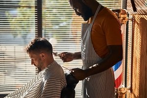 Professional barber creating a clean men's haircut style with clippers in Miramar FL
